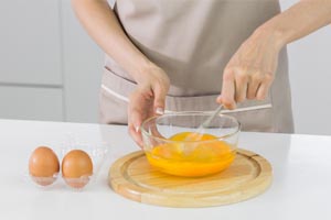 Manos batiendo huevos